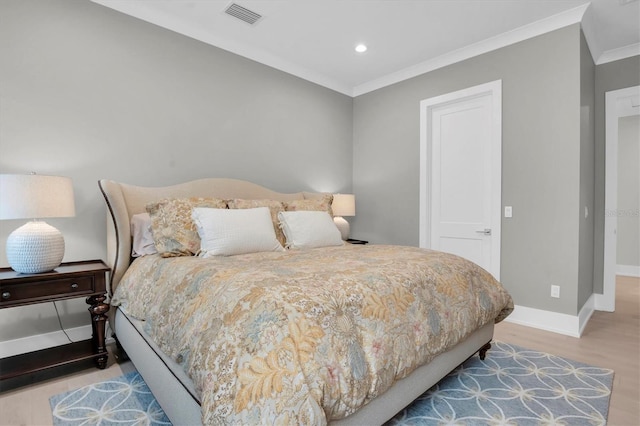 bedroom with crown molding and light wood-type flooring