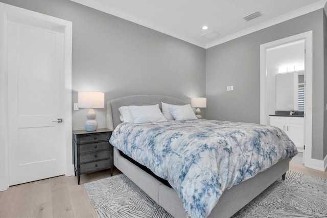 bedroom with connected bathroom, crown molding, and light hardwood / wood-style flooring