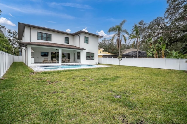 back of house featuring a patio, a fenced in pool, and a lawn