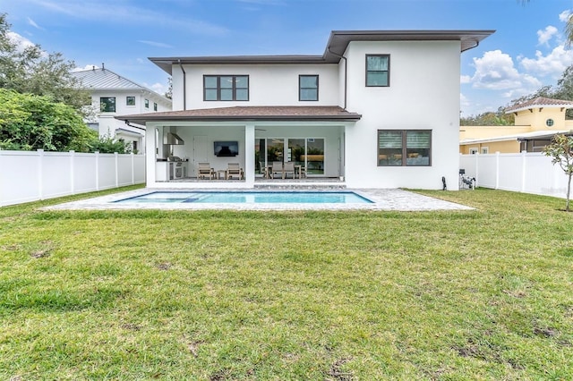 back of property featuring a fenced in pool, a lawn, and a patio area