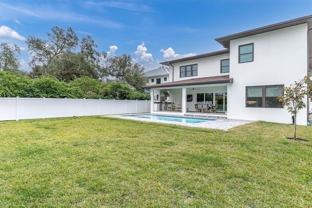 back of property featuring a fenced in pool, a patio, ceiling fan, and a lawn