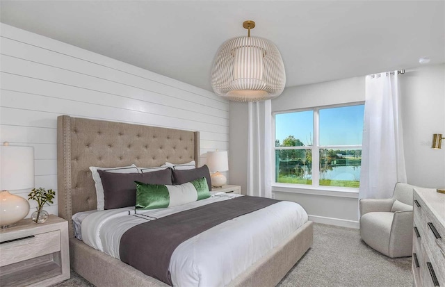 bedroom featuring light colored carpet and a water view