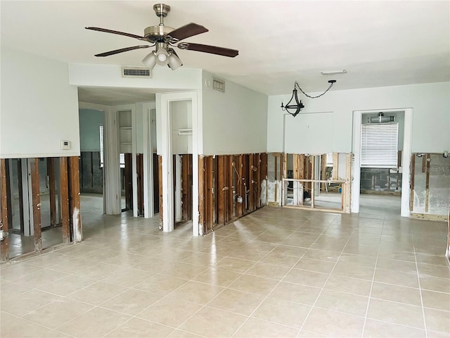 tiled empty room featuring ceiling fan