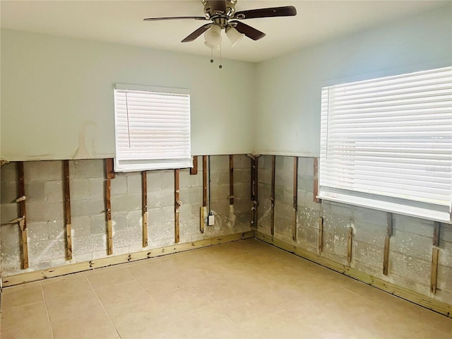 interior space featuring ceiling fan and a wealth of natural light