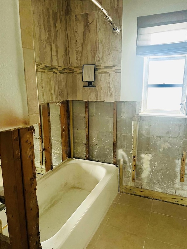 bathroom featuring tile patterned floors and a bath