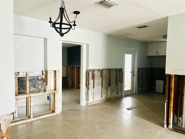 interior space with light tile patterned floors and a notable chandelier