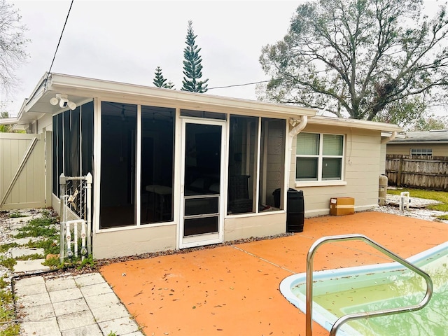 rear view of house featuring a sunroom and a patio