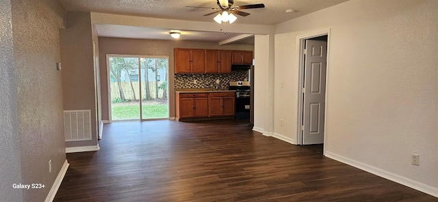 kitchen featuring stove, dark hardwood / wood-style flooring, tasteful backsplash, and ceiling fan