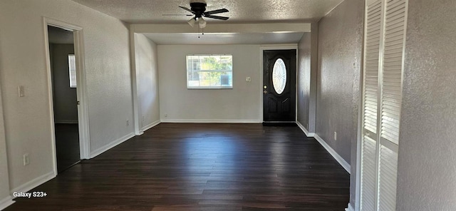 entryway featuring dark wood-type flooring, ceiling fan, and a textured ceiling