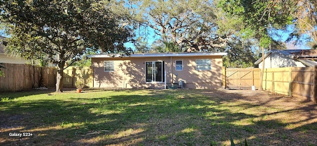 back of house with a lawn