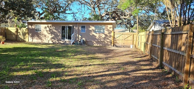 rear view of property featuring a yard