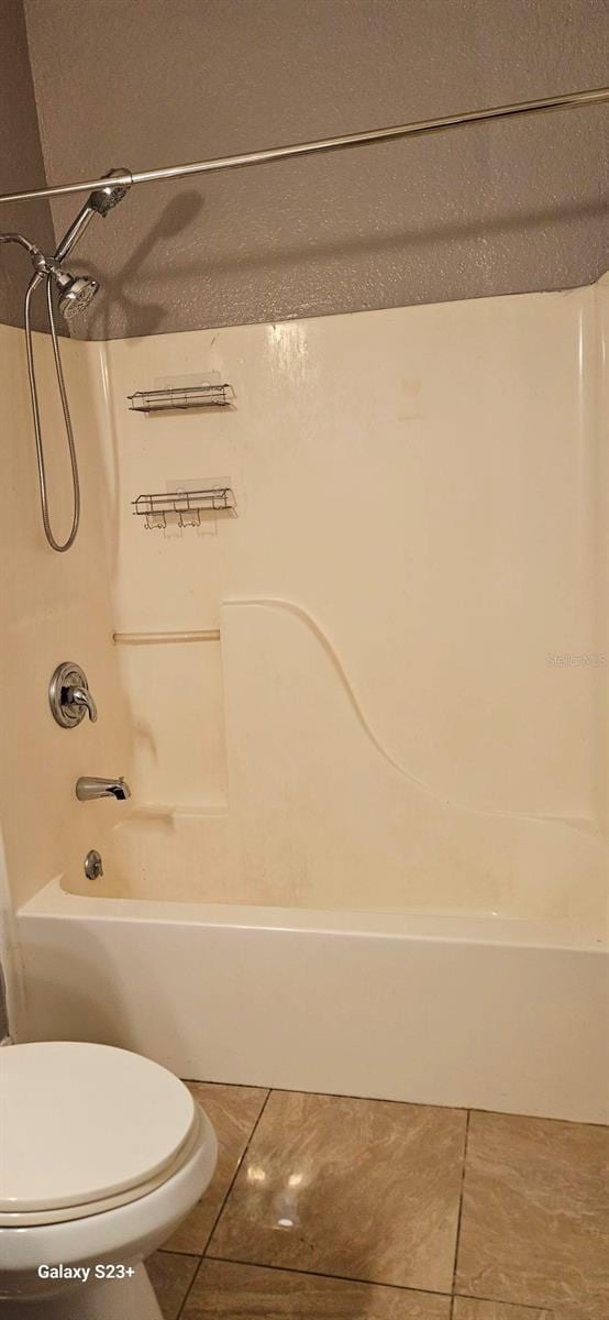 bathroom featuring tile patterned floors,  shower combination, and toilet