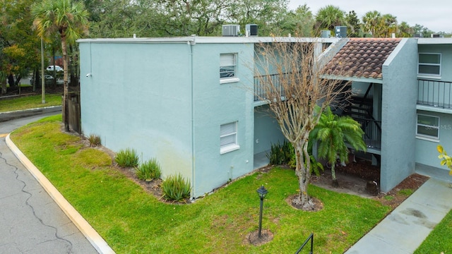 view of home's exterior with cooling unit and a yard