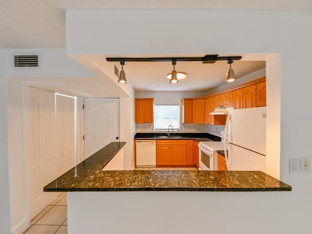 kitchen featuring sink, track lighting, white appliances, and kitchen peninsula