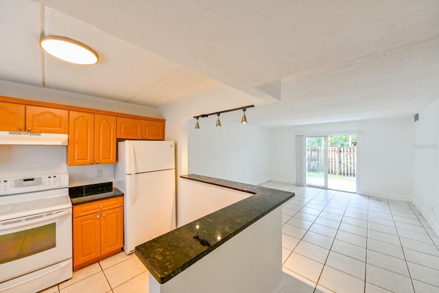 kitchen with light tile patterned flooring, white appliances, and a textured ceiling