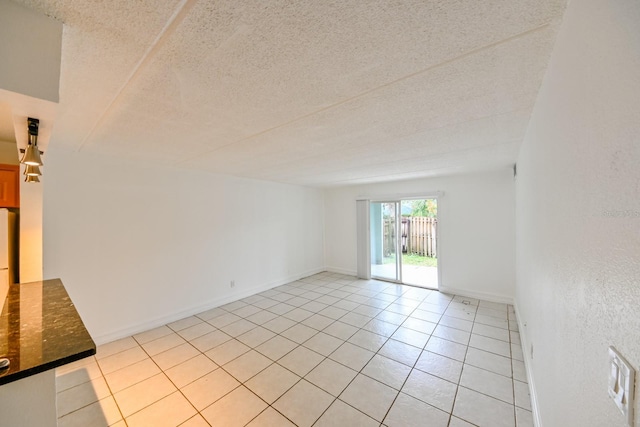 tiled spare room with a textured ceiling