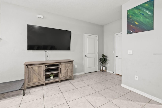 unfurnished living room with light tile patterned flooring and a textured ceiling