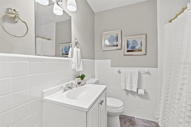 bathroom with vanity, toilet, a shower with shower curtain, and tile walls