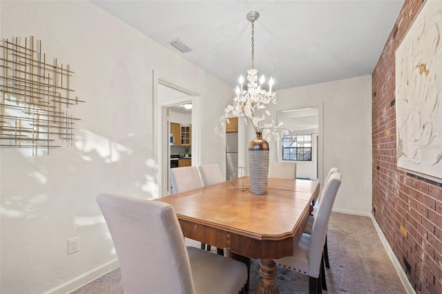 dining room featuring brick wall, carpet flooring, and a notable chandelier