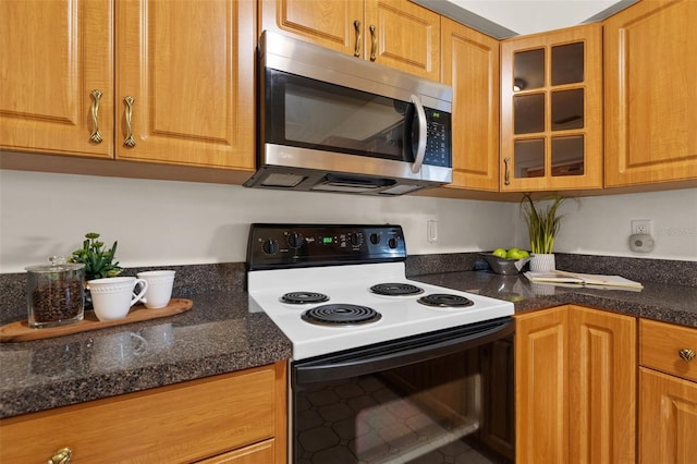 kitchen featuring electric range and dark stone counters