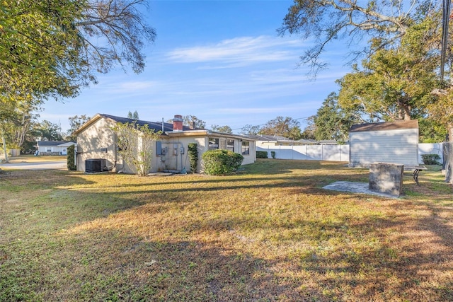 view of yard featuring a storage shed and central air condition unit