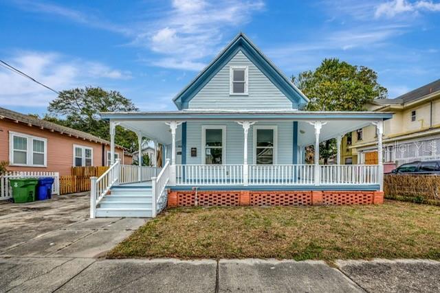 farmhouse-style home with a porch and a front yard