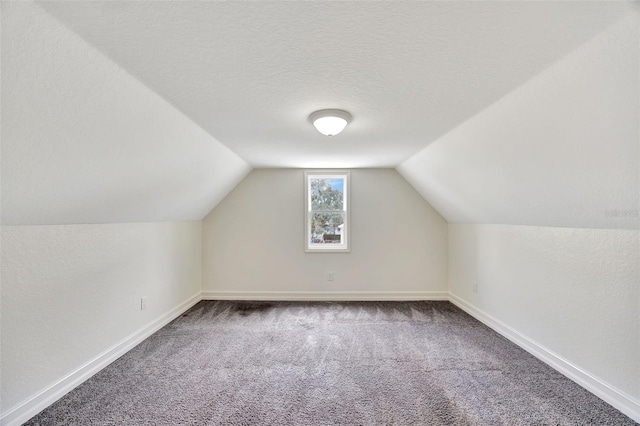 bonus room featuring lofted ceiling, carpet flooring, and a textured ceiling