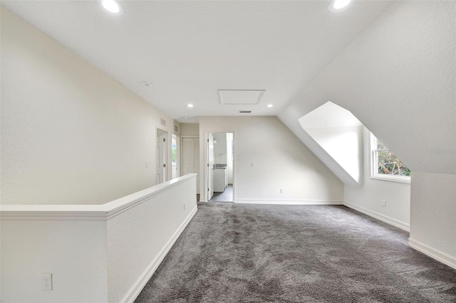 additional living space featuring vaulted ceiling and dark colored carpet