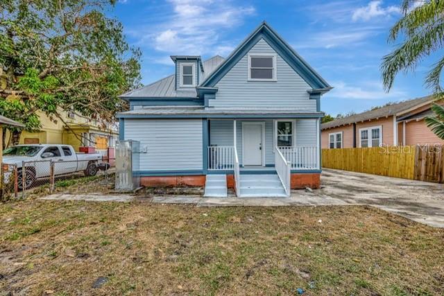 back of property featuring a yard and covered porch