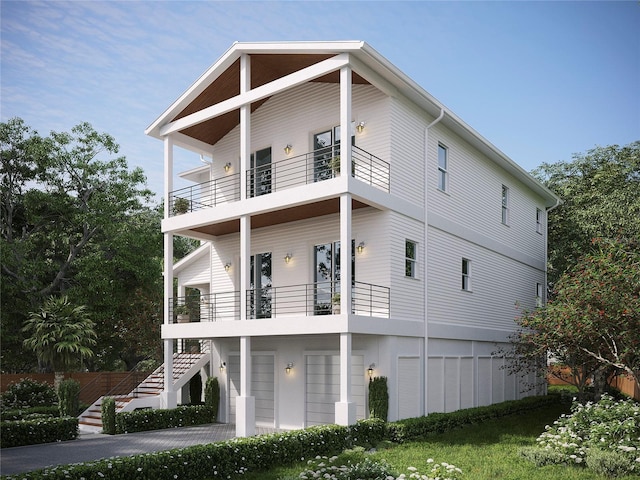 rear view of property featuring a balcony and a garage