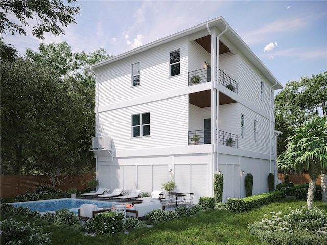 back of house with a balcony, a wall mounted AC, and a patio area