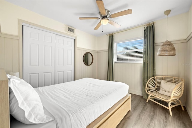 bedroom with hardwood / wood-style flooring, ceiling fan, and a closet