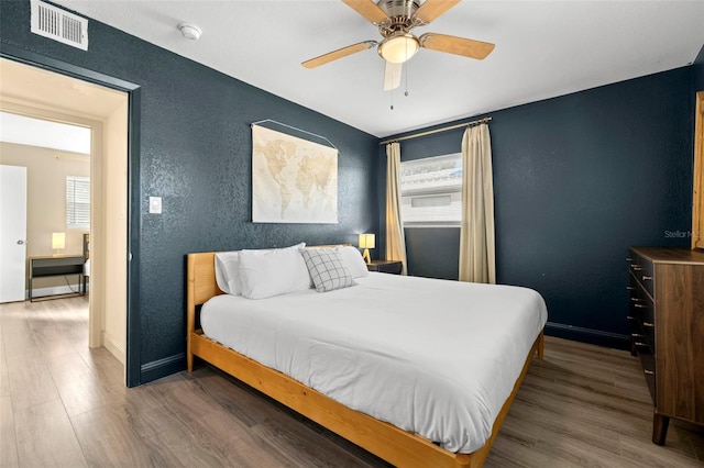 bedroom with ceiling fan and dark hardwood / wood-style floors