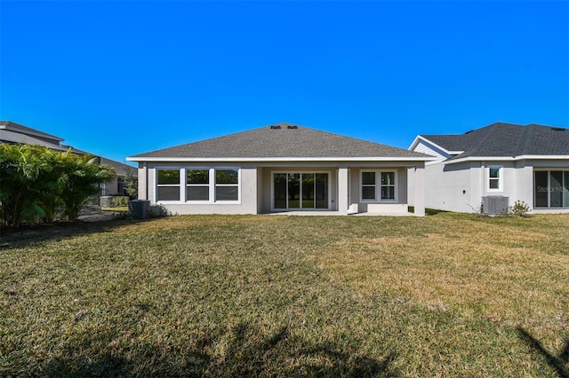 rear view of property featuring central AC unit and a lawn