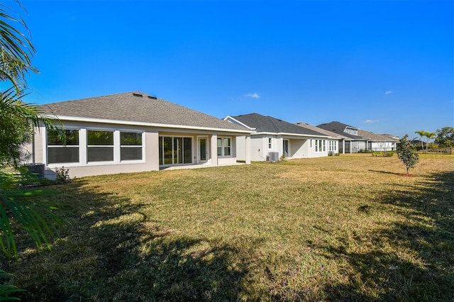 rear view of house with a yard and central AC unit