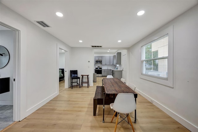 dining area with sink and light hardwood / wood-style flooring