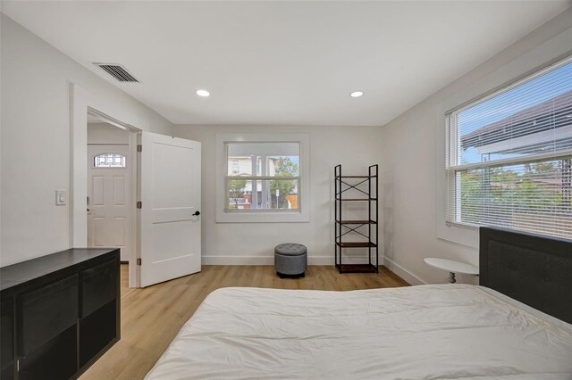 bedroom featuring multiple windows and light hardwood / wood-style floors