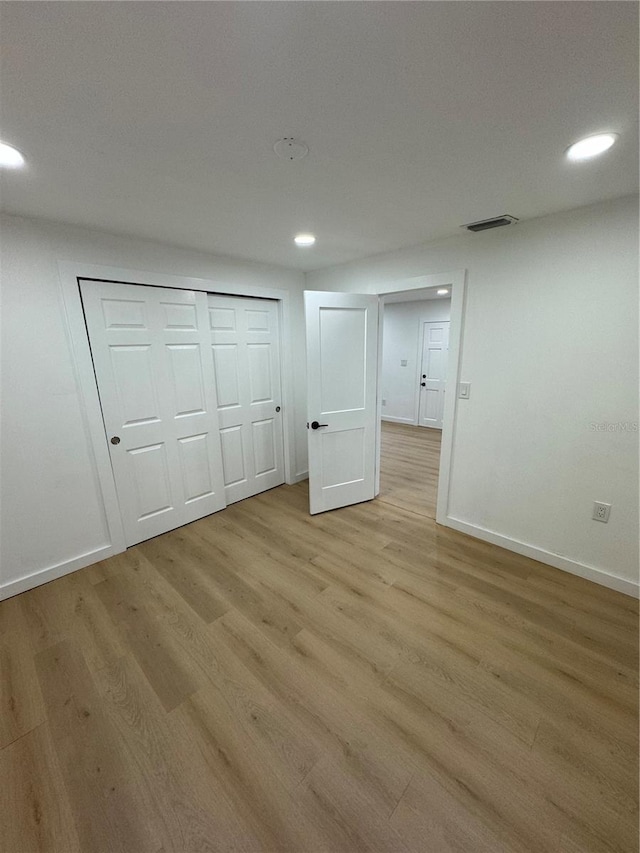 unfurnished bedroom with light hardwood / wood-style floors and a closet