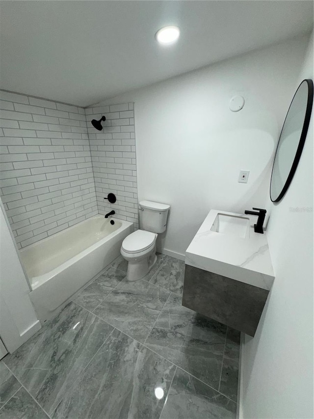 full bathroom with tiled shower / bath, vanity, and toilet