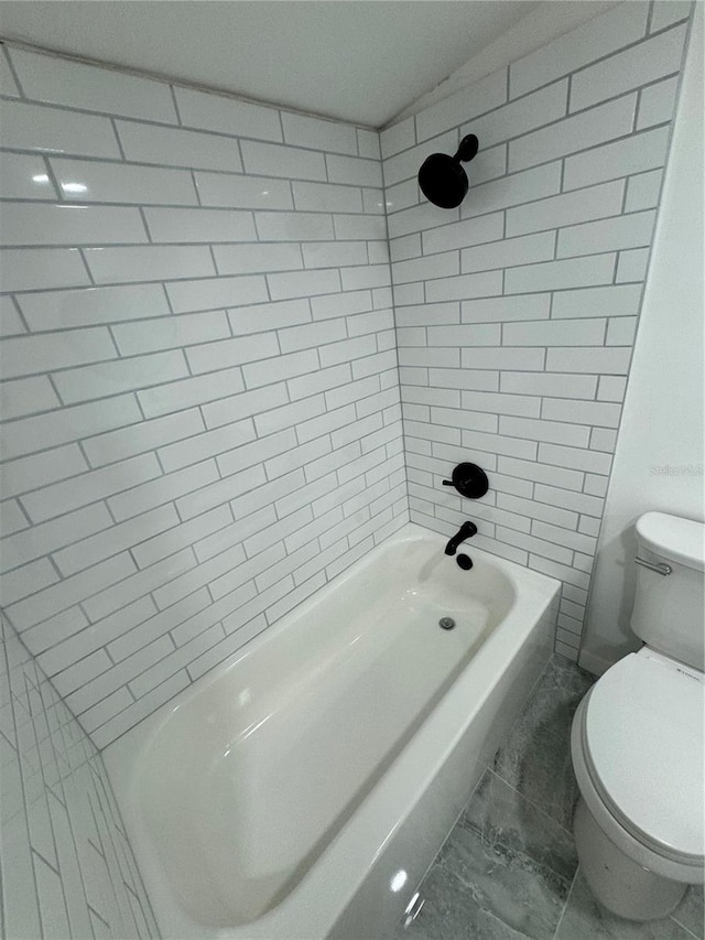 bathroom featuring tiled shower / bath and toilet