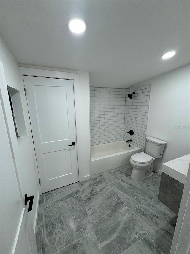 bathroom featuring tiled shower / bath combo and toilet