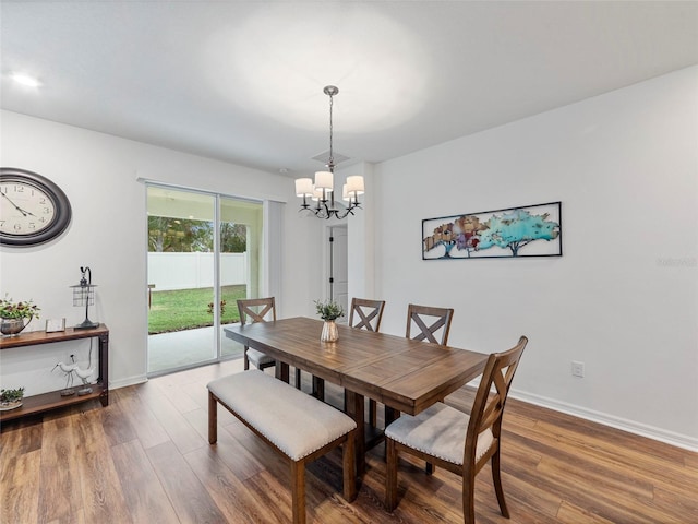 dining room with dark hardwood / wood-style floors and a chandelier