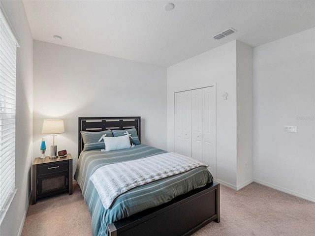 bedroom with light colored carpet and a closet