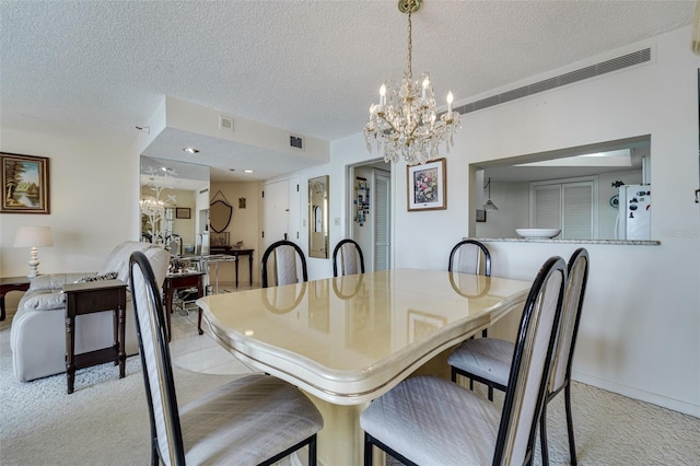 dining area with a textured ceiling, visible vents, a notable chandelier, and light colored carpet