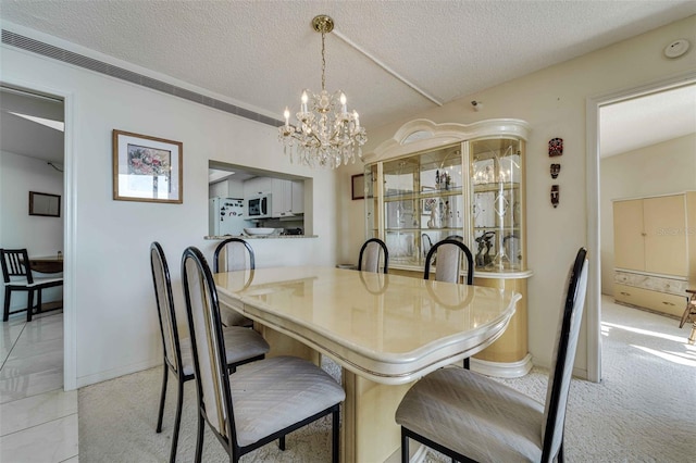 dining area featuring a textured ceiling, light carpet, and a notable chandelier