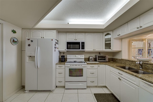 kitchen featuring white appliances, a toaster, white cabinets, and a sink