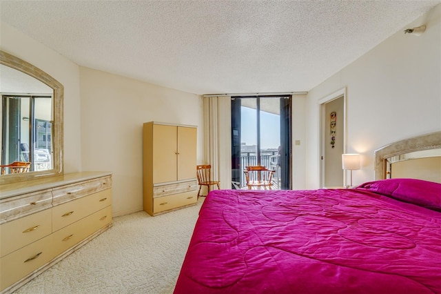 bedroom featuring light carpet, access to outside, floor to ceiling windows, and a textured ceiling