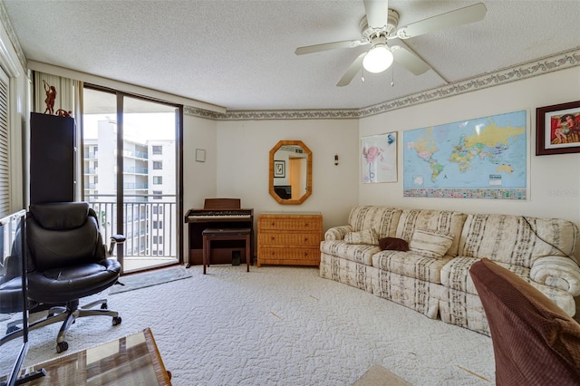 living area featuring carpet floors, ceiling fan, and a textured ceiling