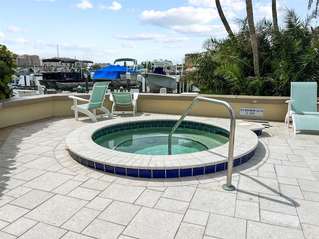 view of swimming pool with a community hot tub, a boat dock, a patio area, and boat lift