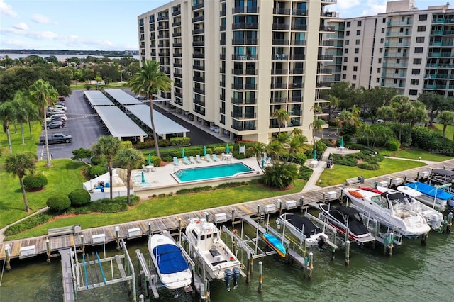 dock area featuring a water view, boat lift, and a community pool